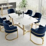 Upgrade your dining space with the “Cassina 001” Elite 6 Seater Dining Set, designed for modern elegance and durability. This luxurious dining table set features a premium quartz marble tabletop and sturdy stainless chrome legs, complemented by six stylish navy blue velvet chairs. Perfect for contemporary dining rooms, the Cassina 001 Elite set offers comfort, sophistication, and lasting quality—ideal for family meals or entertaining guests.