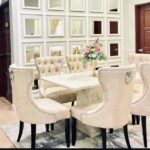 Create an inviting and sophisticated dining experience with the GoodLuck Series Premium 6 Seater Dining Set. Featuring a luxurious cream marble table, this elegant dining room showcases a beautiful floral centerpiece, mirrored wall panels, and stylish modern décor—perfect for both family dinners and entertaining guests. Upgrade your home with this high-quality 6 seater marble dining set for timeless style and comfort.