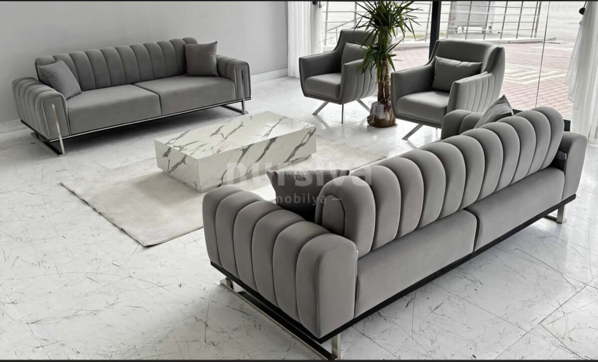 Transform your living space with a modern living room design featuring the luxurious Glory Series IX Premium Fabric 7 Seater Sofa Set. This stylish setup is enhanced by a sleek marble coffee table, a soft beige rug, and a vibrant tall green plant, all beautifully arranged on elegant white tiled flooring. Perfect for those seeking comfort and elegance in contemporary home decor.