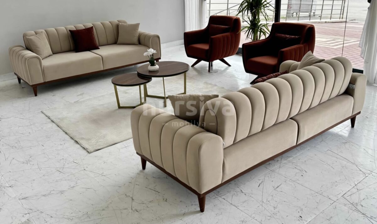 Transform your modern living room with the luxurious Glory Series IX Premium Fabric 7 Seater Sofa Set (3+2+1+1). This elegant arrangement features stylish dark red armchairs, a contemporary round coffee table, a chic area rug, and a lush potted plant — all set atop stunning white marble floors. Large windows flood the space with natural light, creating an inviting and sophisticated ambiance for any home. Elevate your interior décor with this designer sofa set and make your living room both comfortable and visually appealing.